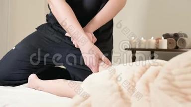 男理疗师按摩师为躺在按摩床上的小孩做一个舒缓足部按摩